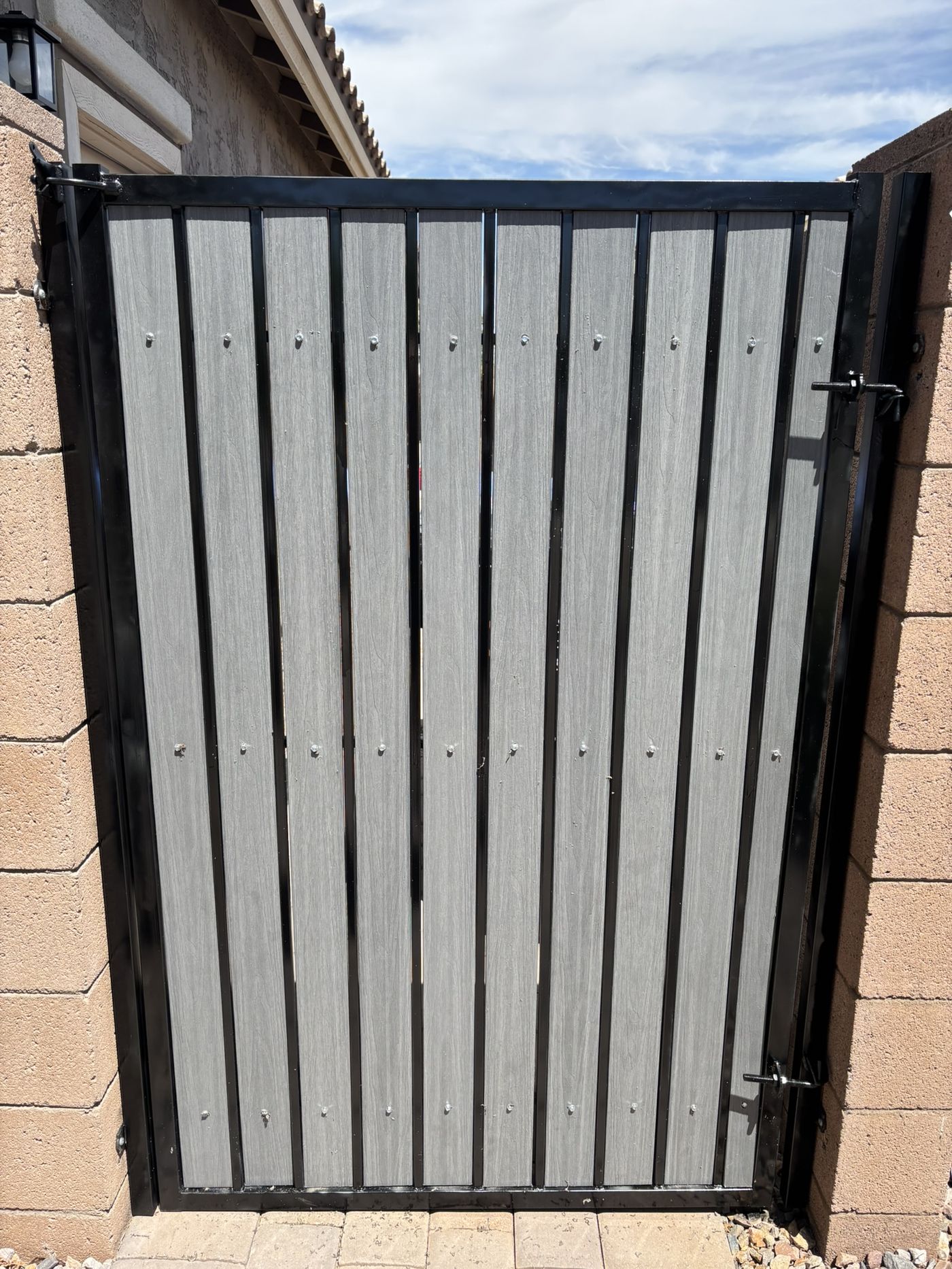 Gate after refurbishment with light grey composite slats and glossy black frame